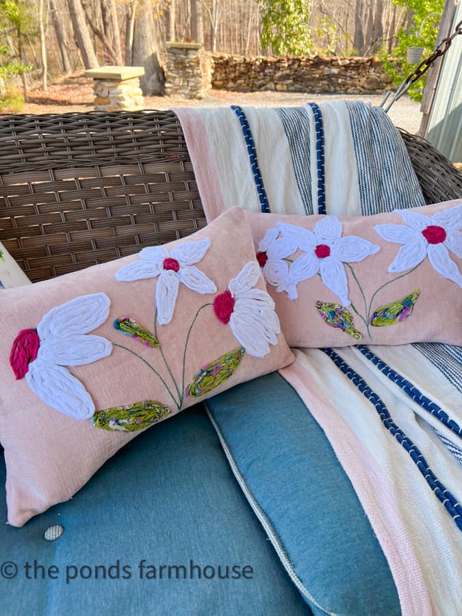 2 DIY Pillow Covers on porch swing.  White petals and pink centers made from scrap fabric