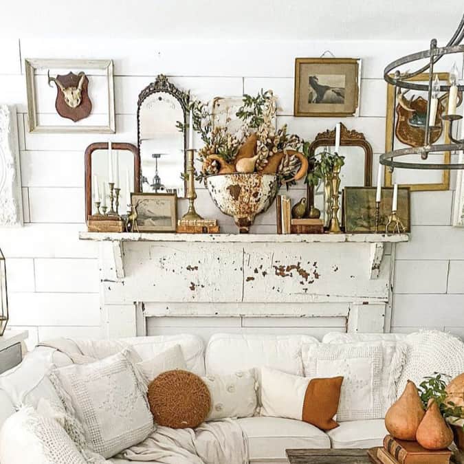 Make a gallery wall over a faux fireplace mantel using vintage frames to surround mounted antlers and add old mirros.