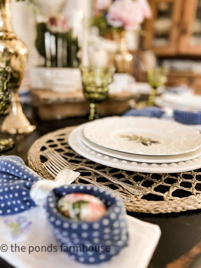 Thrift Store floral dinner plates with woven placemats and vintage silverware.  Budget Farmhouse Style Easter Decor.