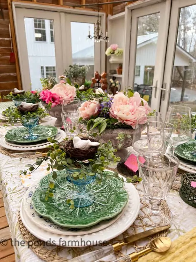 Dinner Party in Greenhouse with Cabbage Plates and blue dessert glasses filled with greenery and birds nest.