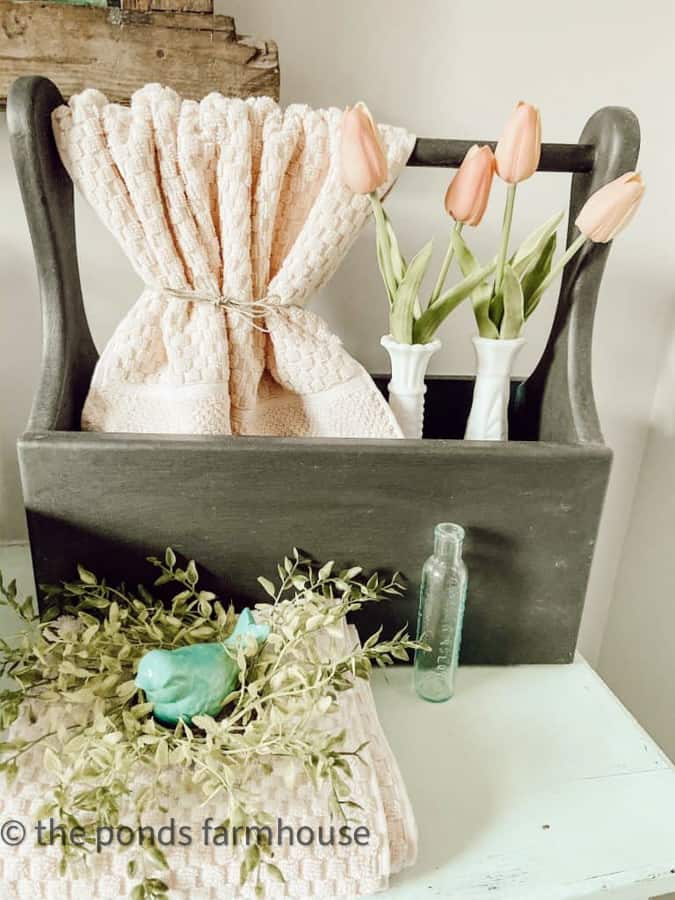 Use a vintage thrifted tool box for hand towel holder with milk glass vases filled with tulips