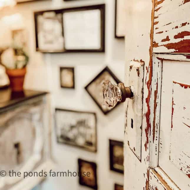 Vintage old door and glass door knob in powder room with gallery wall