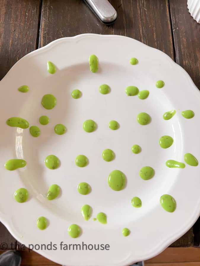Decorate white dinner plate with green salad dressing to build a layered salad recipe upon.