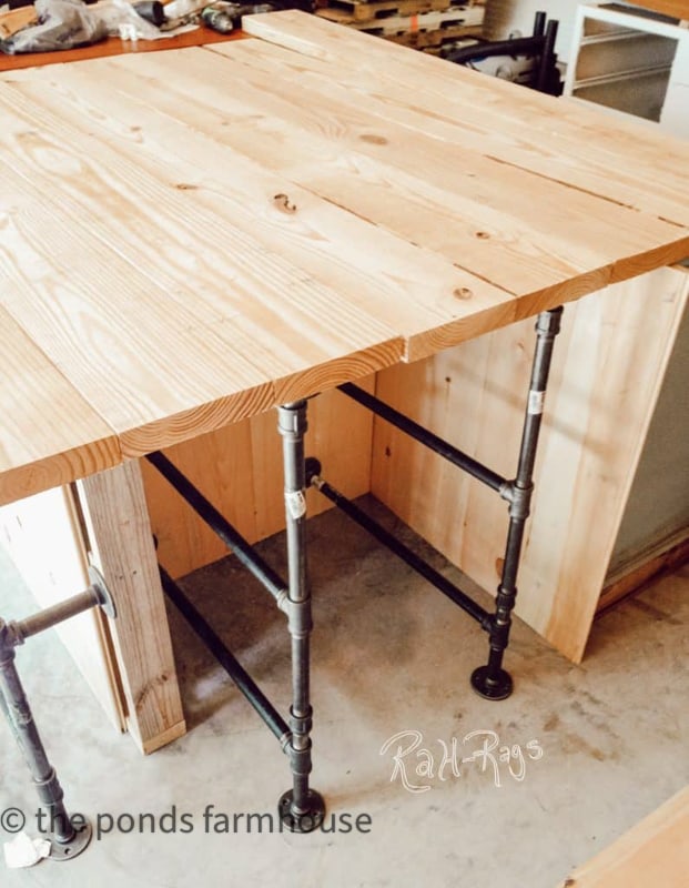 Metal pipe used to create shelving in the industrial style rustic farmhouse kitchen island.