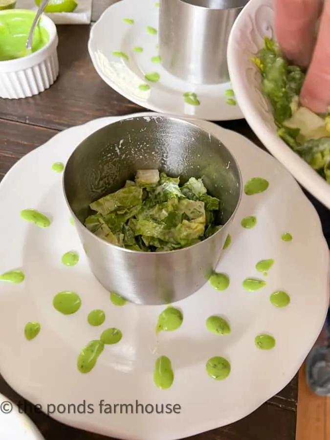 Make a layered salad recipes with metal round mold which is filled with ingredients for cobb salad.
