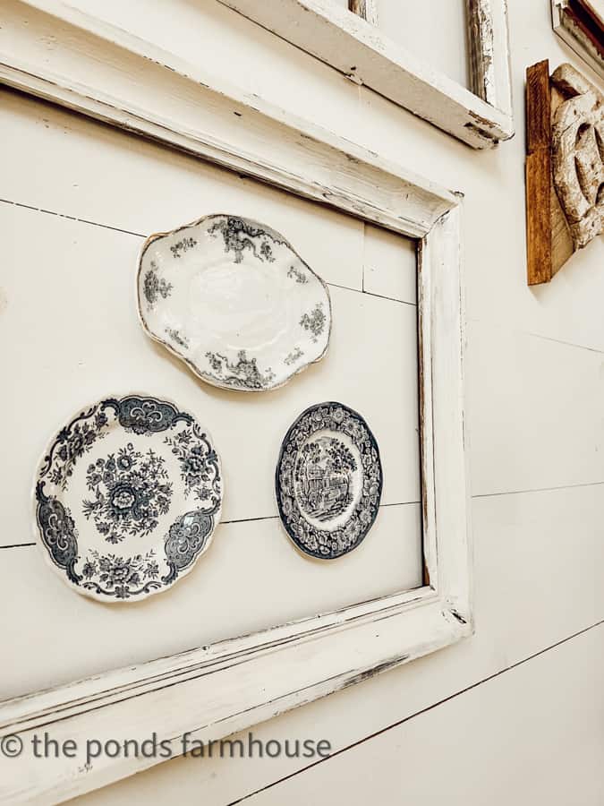 Vintage transferware dishes displayed inside a old picture frame. Thrift Store finds for farmhouse decor.