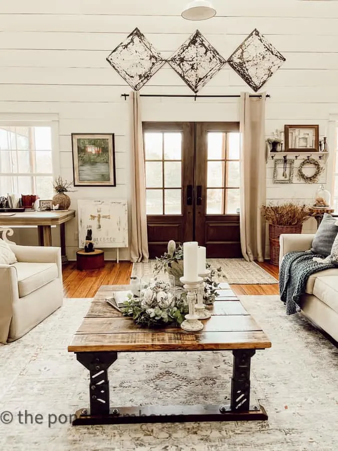 Coffee Table with a view of french front doors and antique ceiling tiles on Shiplap Walls in Farmhouse entry.