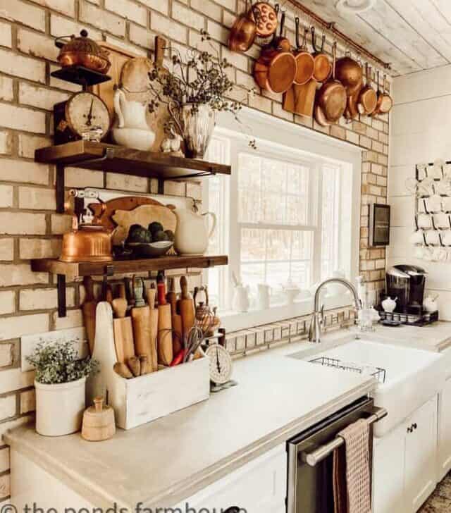 open-shelves-with-cutting-boards-and-rolling-pins-with-copper-pot-hanging-rack-in-background.-
