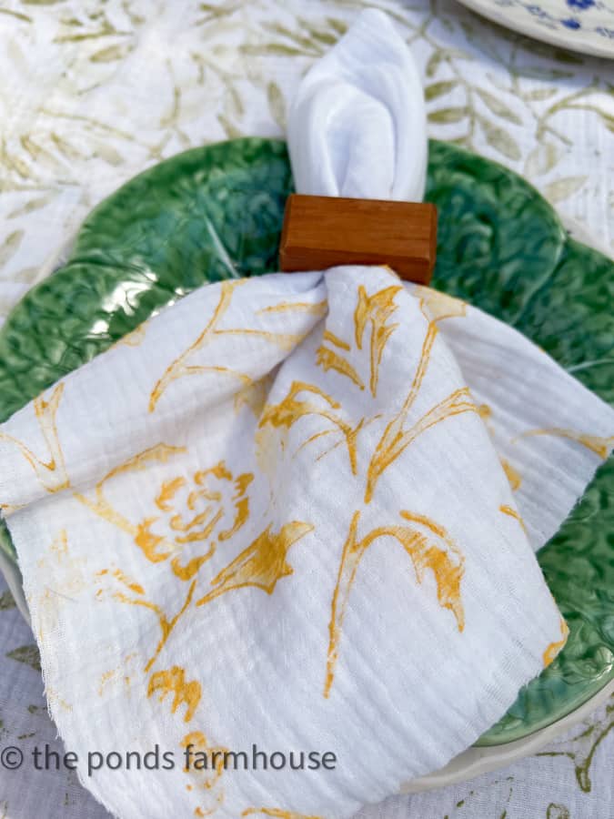 Custom napkin with wooden napkin ring on green leaf plate for a unique table linen.  