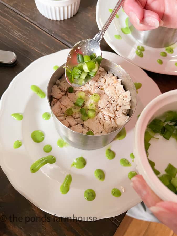 Garnish the top of the layered Cobb Salad With Chicken by chopping green onions.  