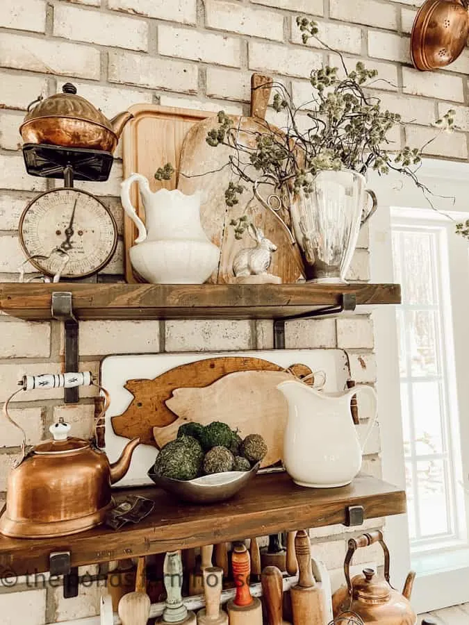 Open shelving with pig cutting boards, ironstone pitchers, copper and silver mixed with vintage scale.