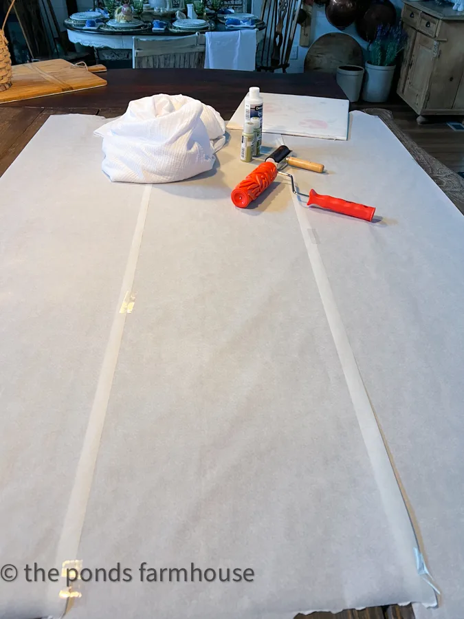Tabletop covered with protective parchment paper and supplies to make custom table linens 