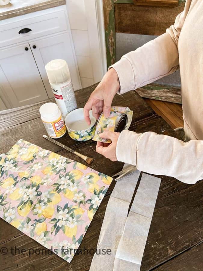 adding napkin to the recycled tin cans