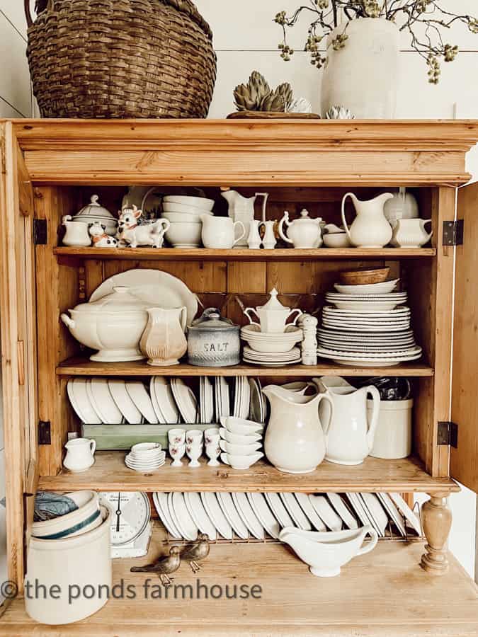 Ironstone fill a antique pine hutch. Classic Woods and Whites decor for a country chic farmhouse style.  