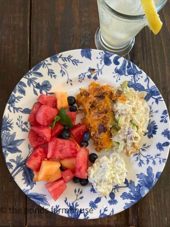 Hot Chicken Salad with Fruit Salad on Blue & White Plate with Lemonade