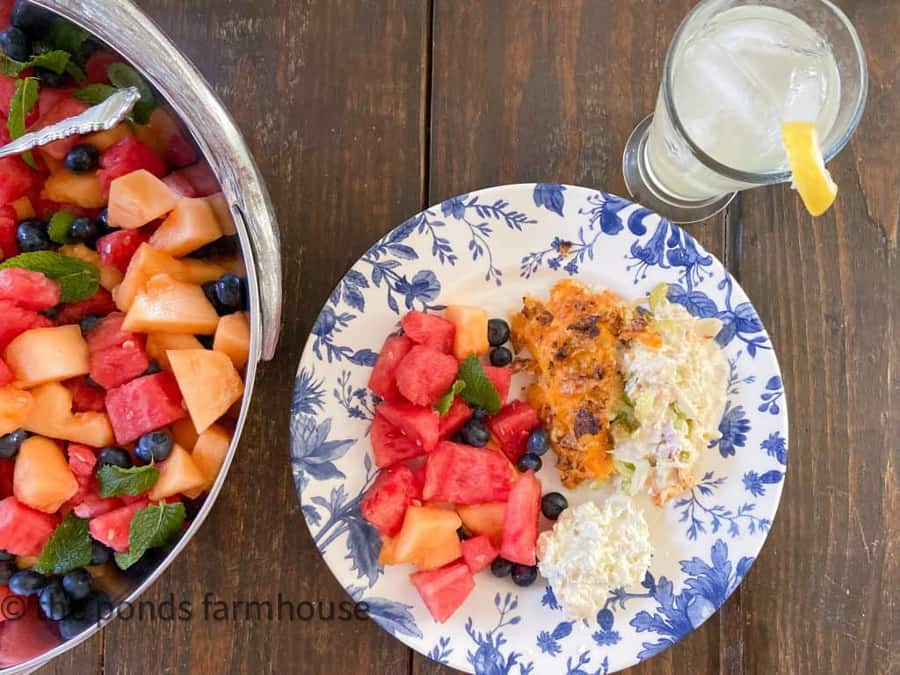 Hot Chicken Salad with Fruit Salad on Blue & White Plate with Lemonade