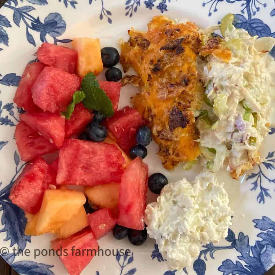 Hot Chicken Salad with Fruit Salad on Blue & White Plate