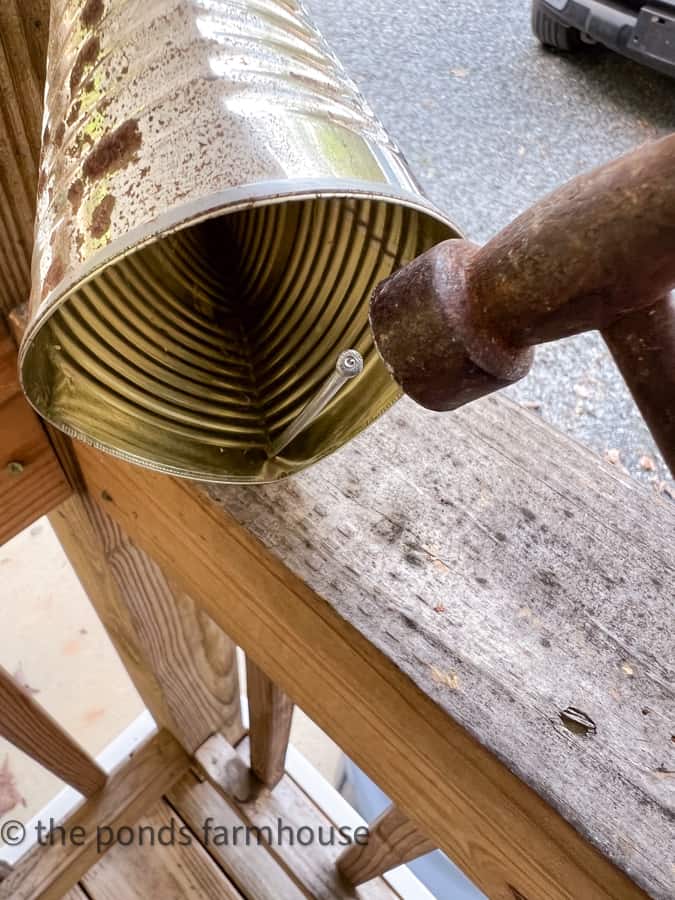 Use nail to punch hole in sides of recycled tin cans for DIY pockets for flowers and plants.  