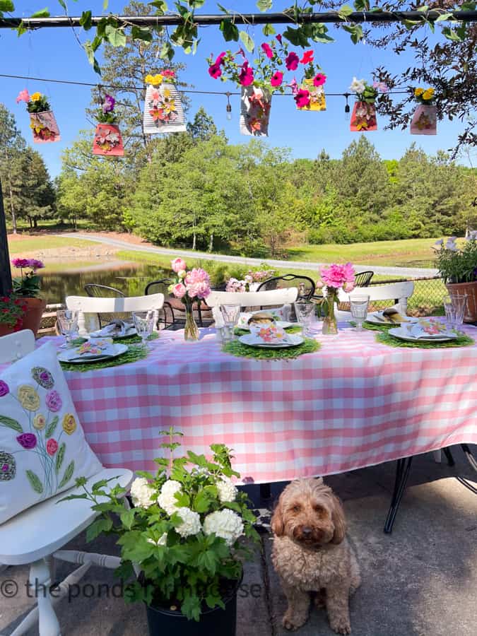 Alfresco Dining for Mother's Day Luncheon Ideas with pink & White tablecloth, DIY flower pots and peonies - mini golden doodle. 
