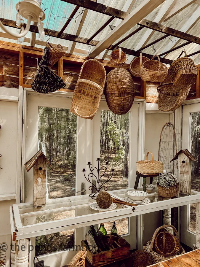Basket Decor Ideas - fill the DIY Ladder with thrifted vintage baskets in greenhouse above DIY potting table.  