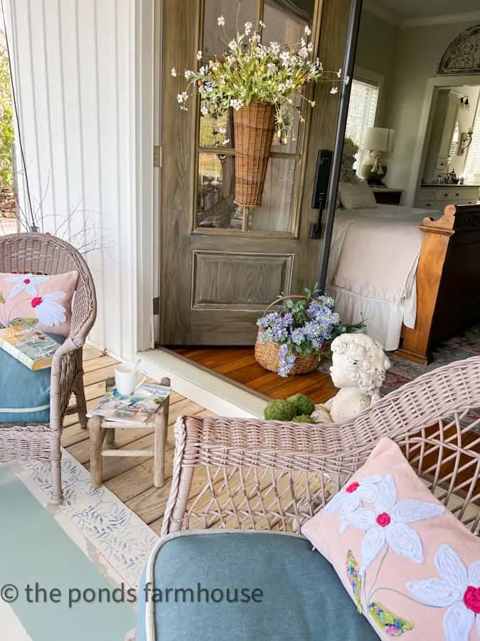 Cozy Sitting area on front porch at bedroom doors with baskets of flowers for front porch sitting
