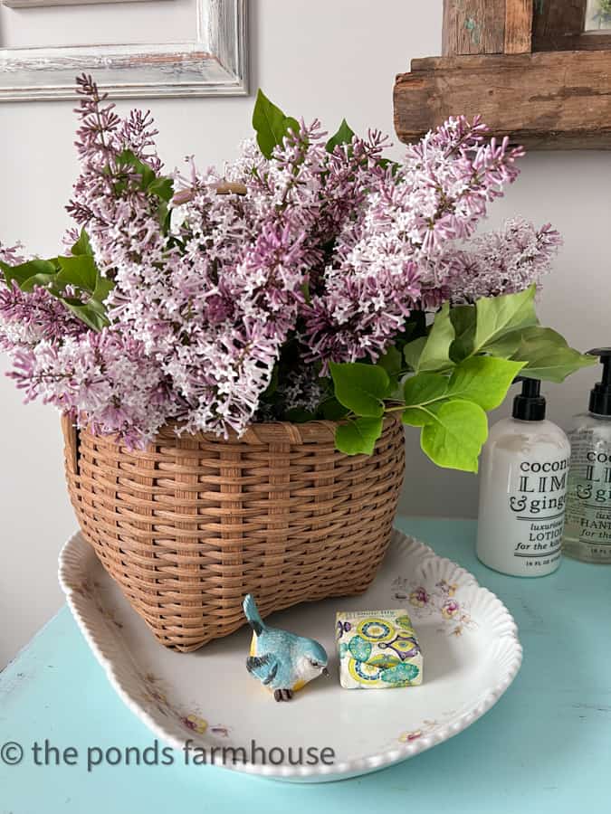 Decorate with baskets filled with fresh lilac blooms on vintage tray in bathroom.