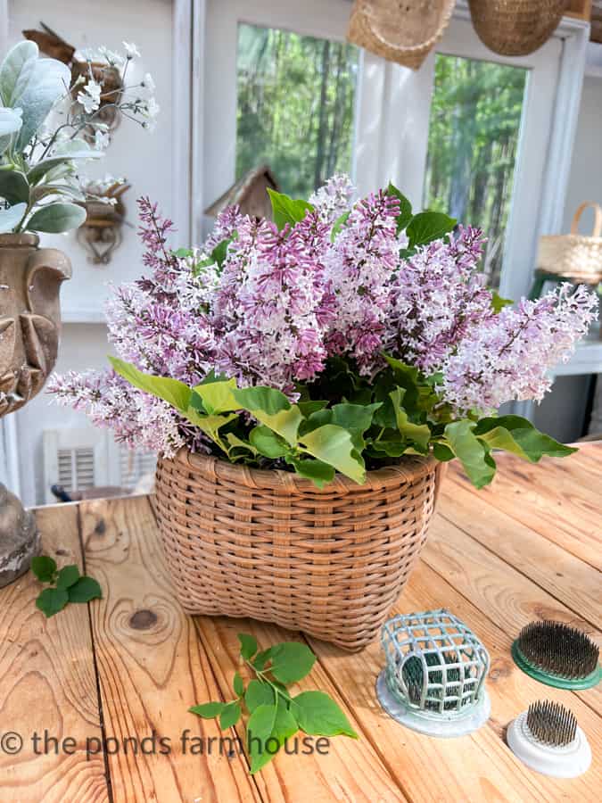 Decorate with baskets using fresh lilac blooms arranged in a woven basket for a modern farmhouse style.  