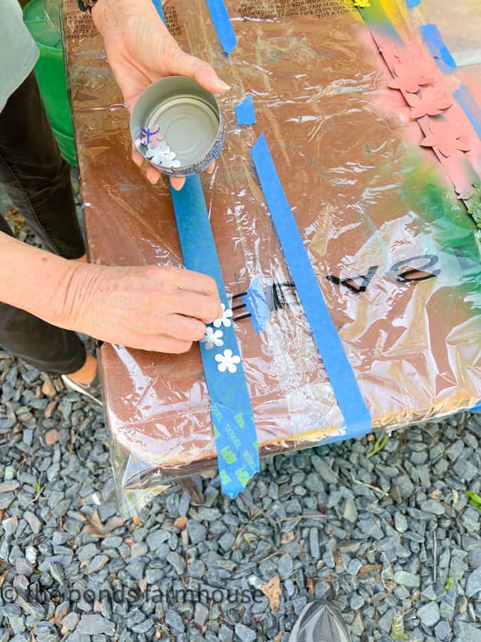 Use painters tape to secure the aluminum flowers for spray painting. 