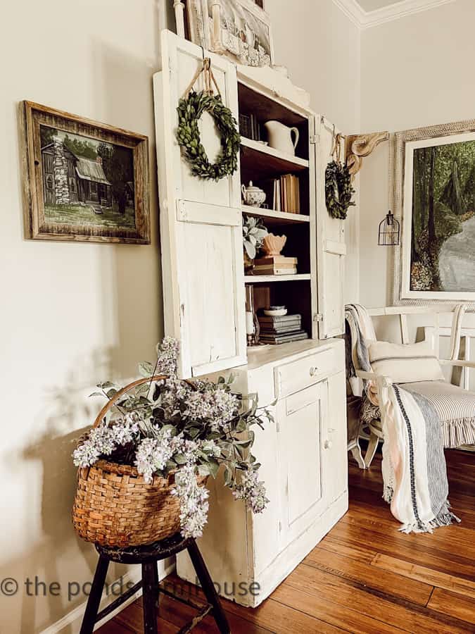 Step back hutch with vintage stool and basket of lilacs for Vintage bedroom decor ideas.  