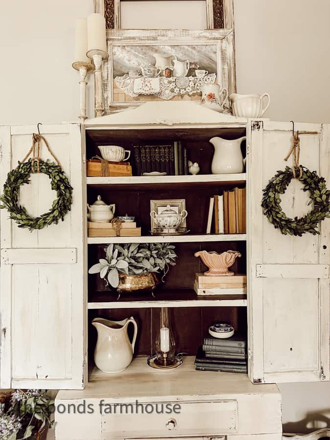Hutch is decorated with vintage finds from thrift stores for Farmhouse Style bedroom decorating.