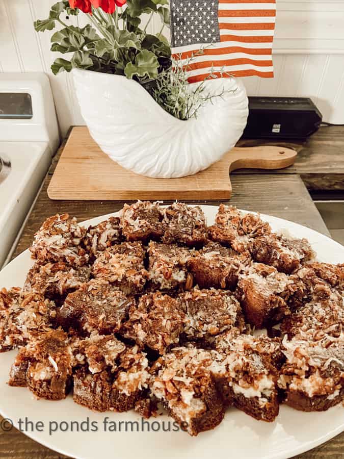 Upside down German chocolate cake cut in squares on a white platter.  