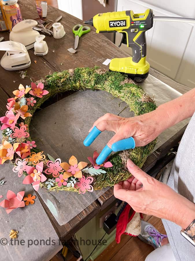 Use finger protectors to attach the recycled aluminum can flowers to the DIY Metal Wreath.