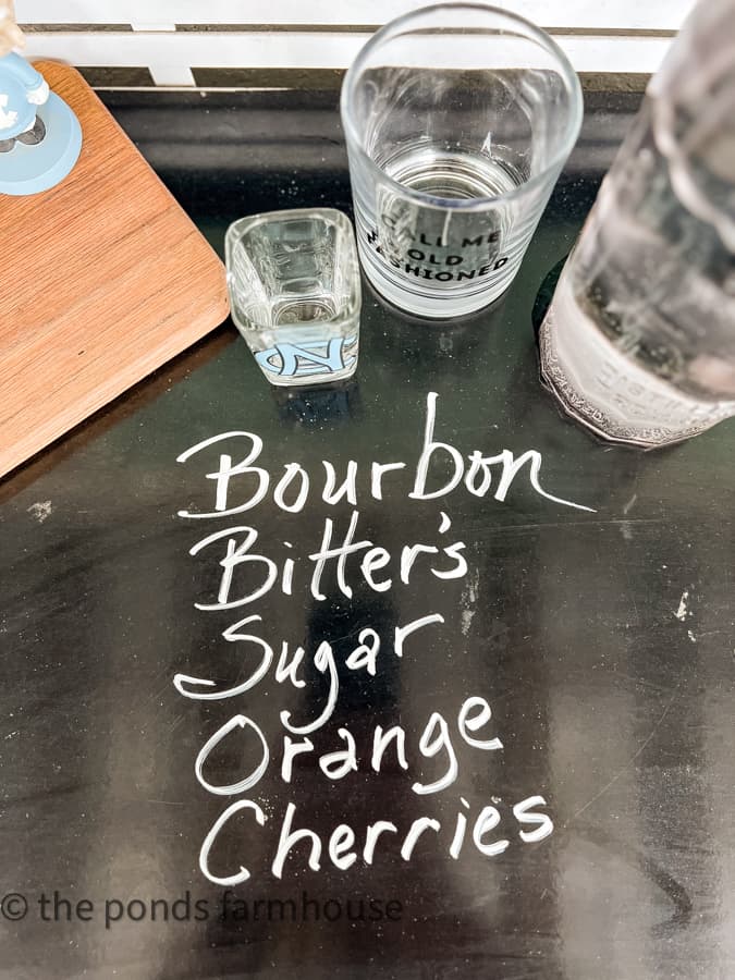 Old Fashioned Cocktail recipe written in chalk on the bar table. 