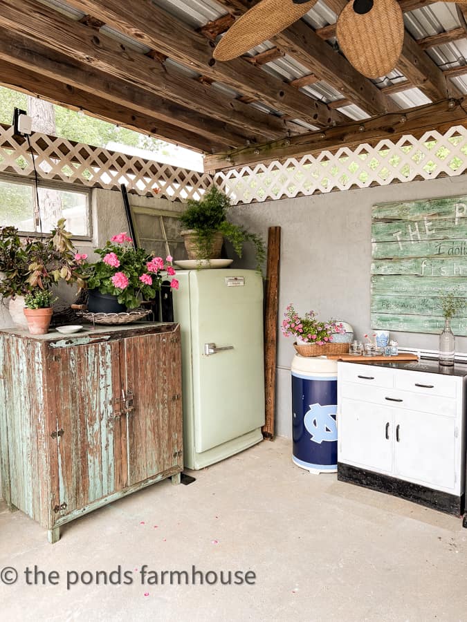 Outdoor Kitchen with primitive cupboard and vintage refrigerator and UNC Bar Setup.