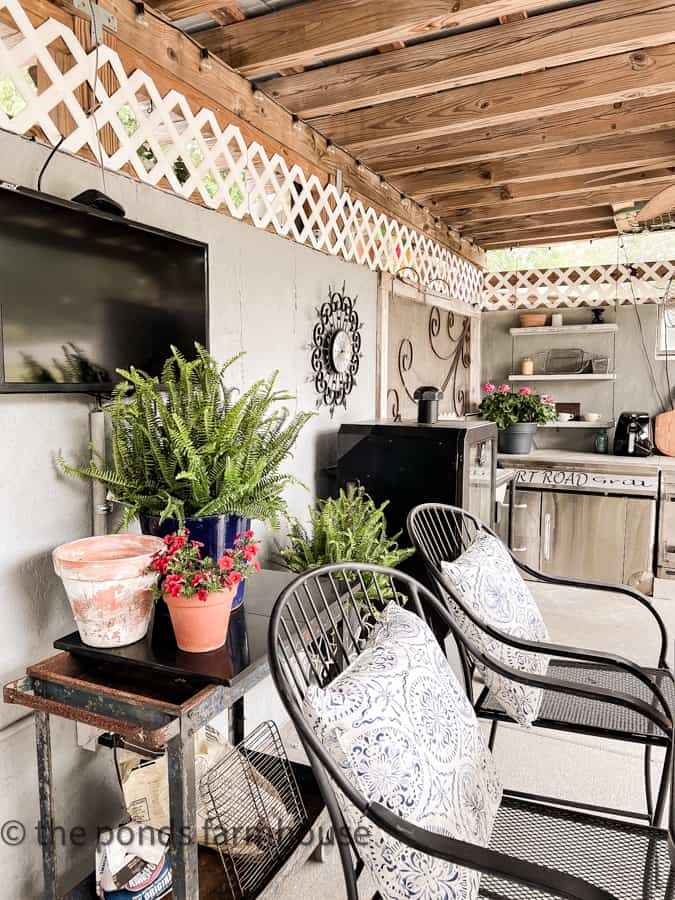 Outdoor Kitchen with vintage decor and blue and white pillows in bar chairs.  Father's Day Dinner Ideas