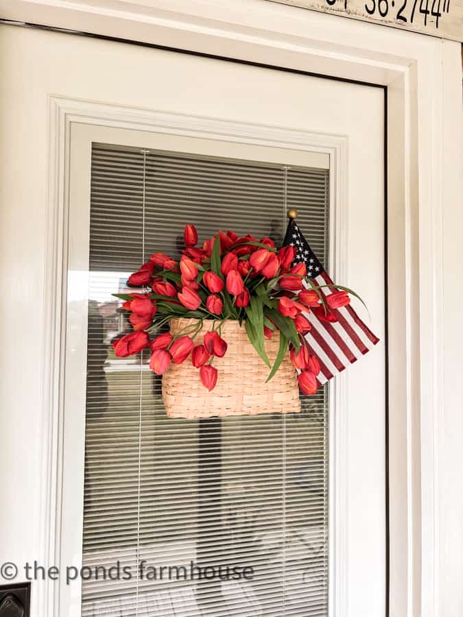 Add a patriotic basket to the door filled with red tulips and a flag for 4th of July decorating.