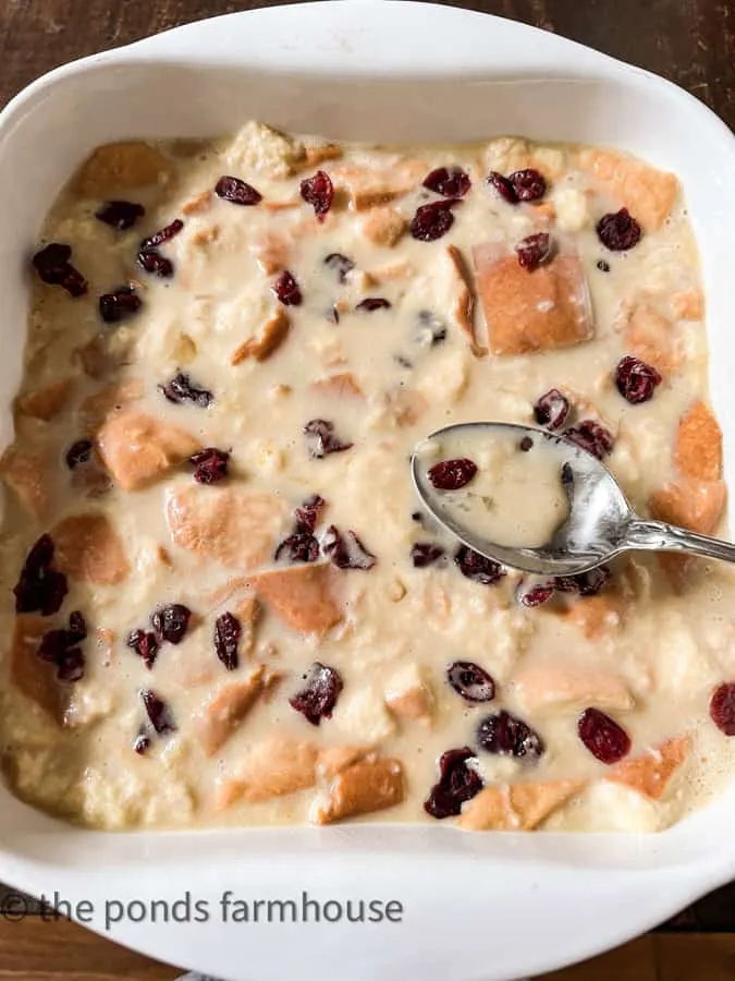 Pour bread pudding ingredients into baking dish with dried cherries.