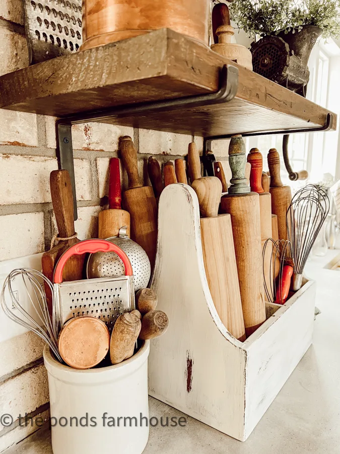 Crocks filled with vintage utensils in a farmhouse kitchen.  