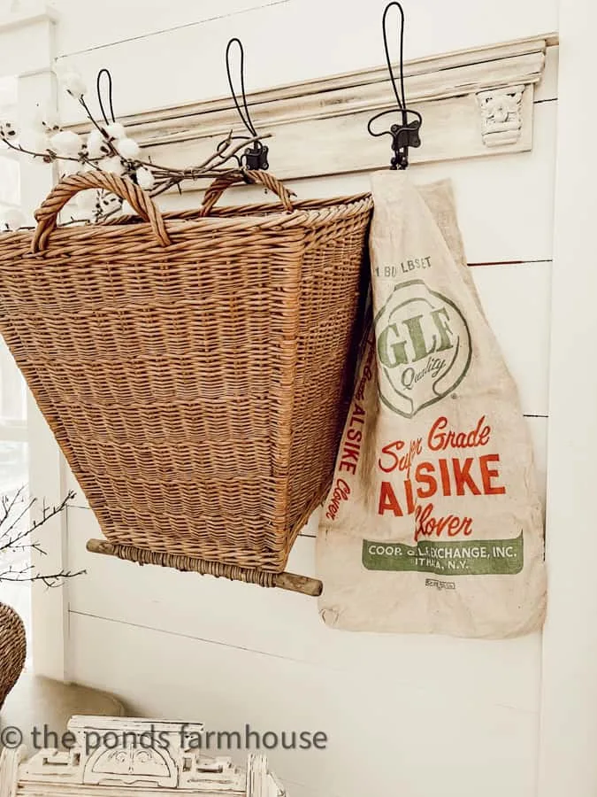 Vintage feed sack with gathering basket hanging on the wall.