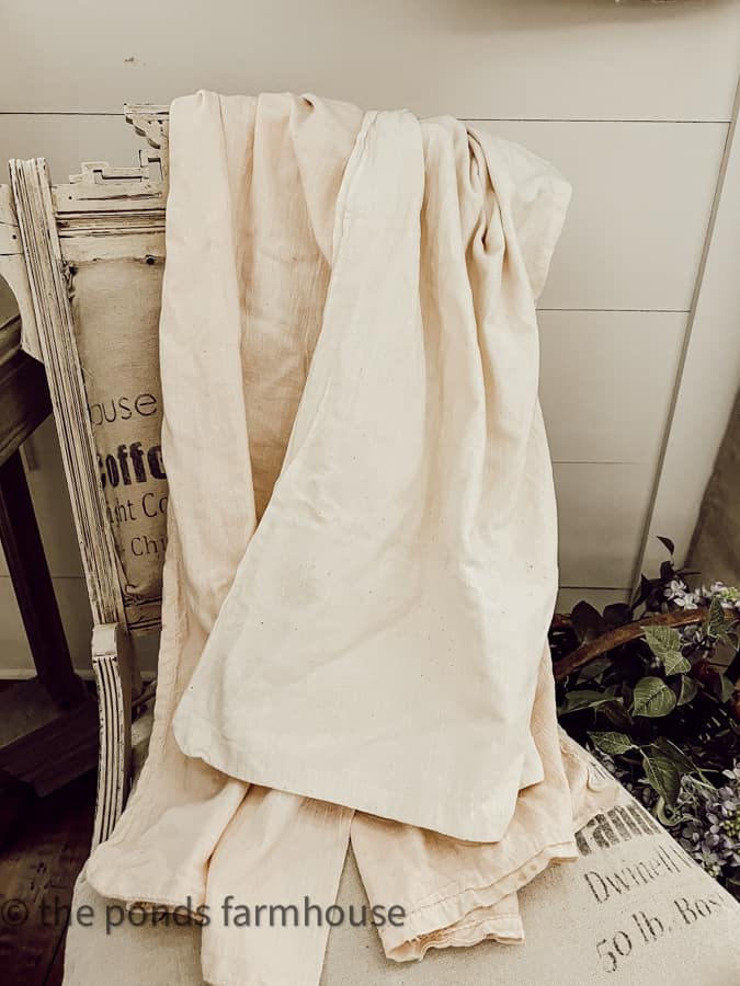 white & pink vintage feed sacks on a deconstructed chair.