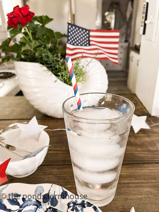 Water with patriotic straw on a 4th of July table setting.
