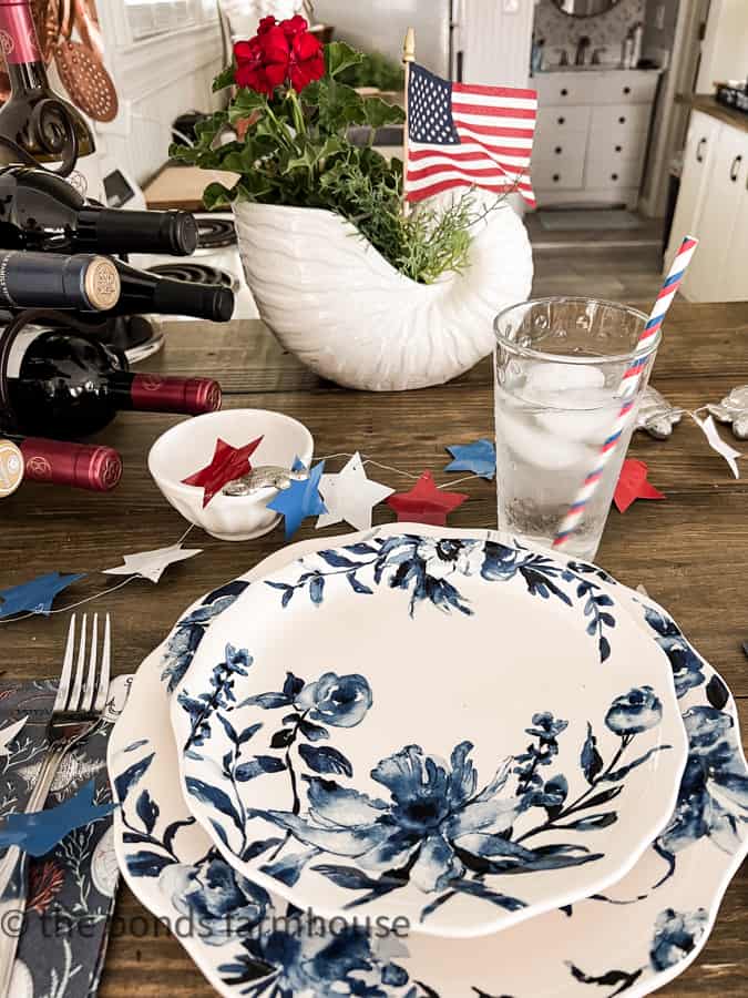 Patriotic table setting with blue and white dishes and star garland.  