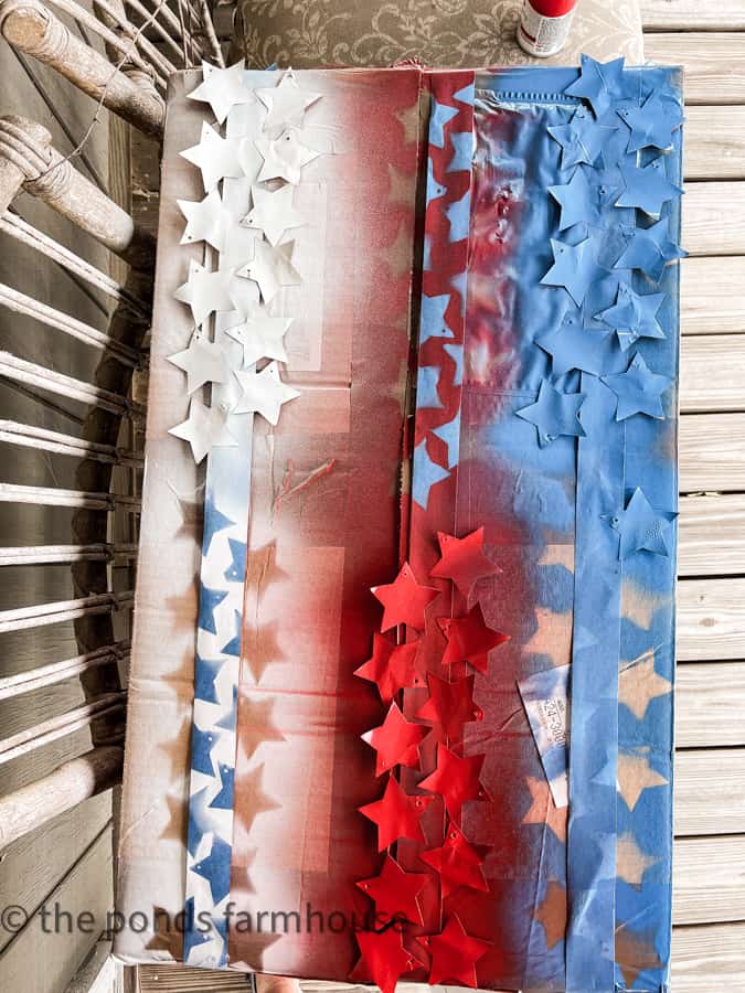 Use painters tape to attach aluminum stars to paint them red white and blue.