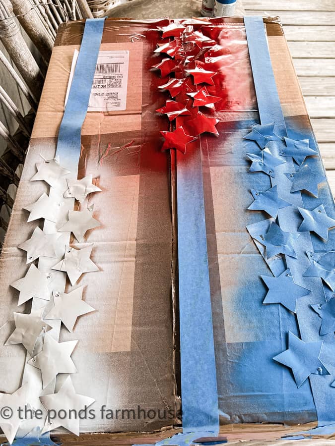 Use painters tape to attach aluminum stars to paint them red white and blue.