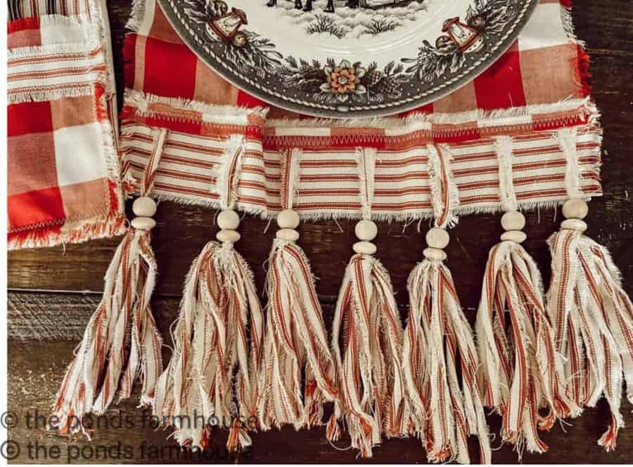 Festive table runner with ticking tassels and buffalo prints in red and white.  Holiday home decor.