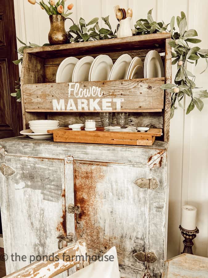 Style a wooden flower box with vintage ironstone dishes and brass.