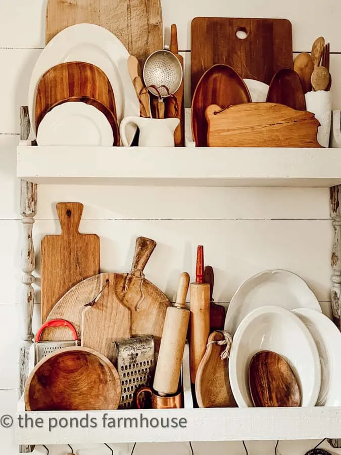 Plate rack is filled with vintage kitchen utensils & vintage rolling pins in a modern farmhouse kitchen 