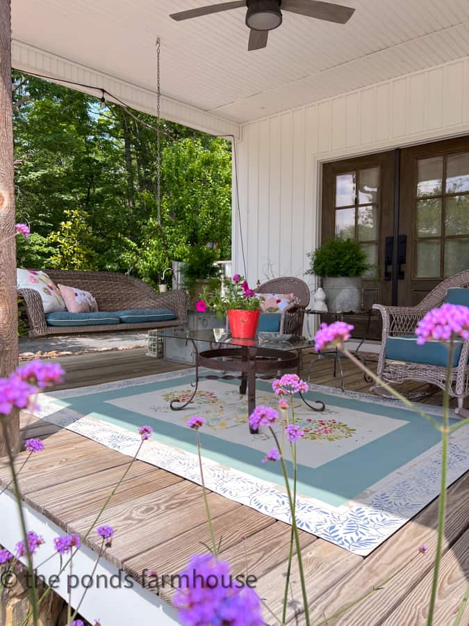 Farmhouse style Country Porch Seating area with swing and vintage wicker chairs.