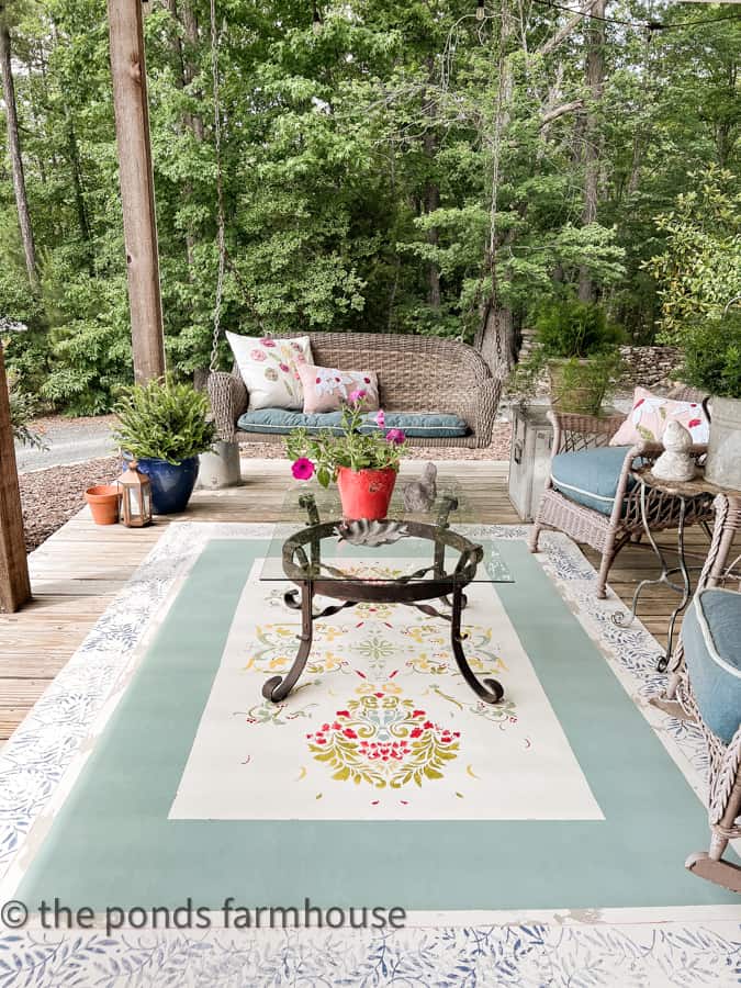 Front porch swing with iron coffee table and wicker furniture. DIY Rug.