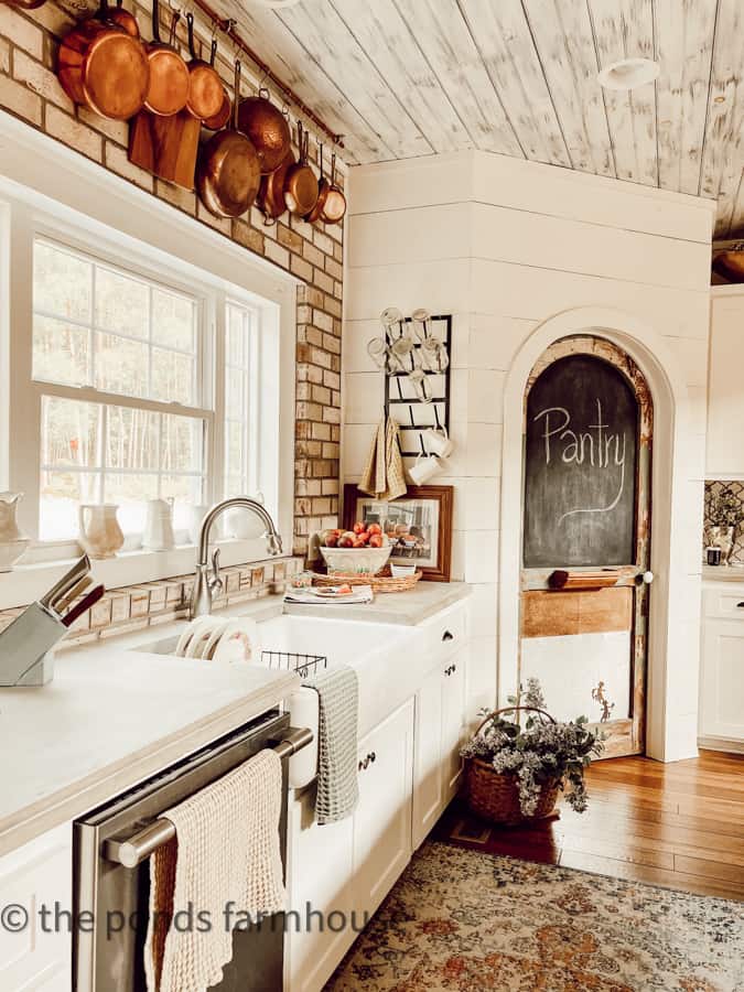 Farmhouse Kitchen Sink with concrete countertops and brick back splash  and DIY Pantry Door.